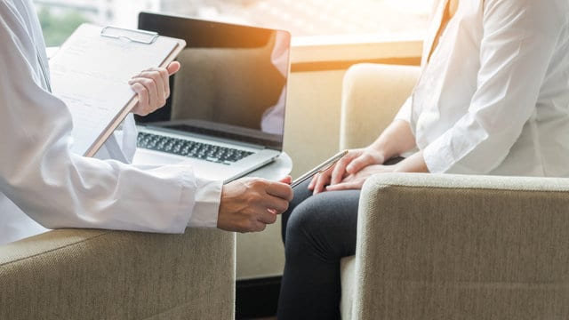 Doctor consulting and examining woman patient's health in medical clinic or hospital professional se