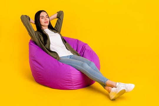 Wide Width Shoes: Your Guide To A Comfortable and Stylish Fit 3 Full size photo of cute young lady sit on bag wear shirt jeans sneakers isolated on yellow color bac